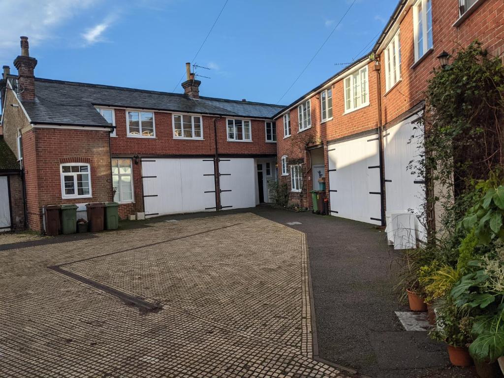 un aparcamiento vacío frente a edificios de ladrillo en Lovey Stable mews in hidden location, en Royal Tunbridge Wells