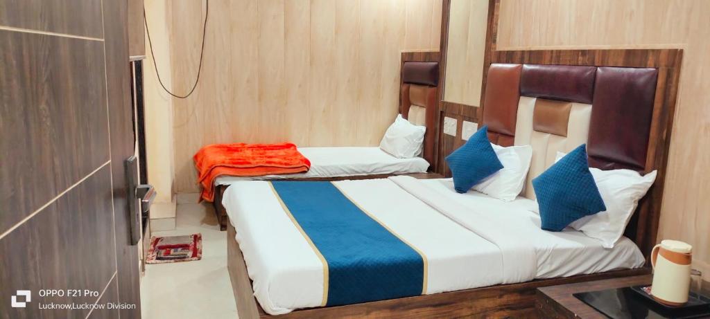 a bedroom with two beds with blue and white at HOTEL PLUTUS in Lucknow