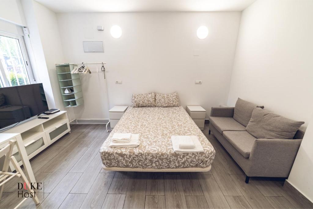 - un petit salon avec un lit et un canapé dans l'établissement Aluche Apartments, à Madrid