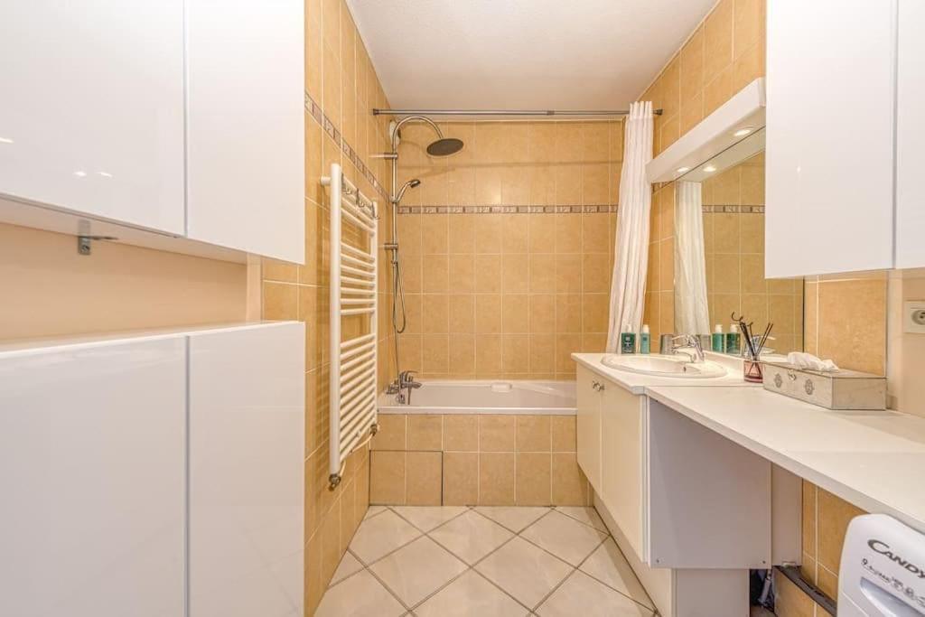 a bathroom with a tub and a sink and a shower at Standing, balcon avec vue, clim, tt équipé confort in Échirolles