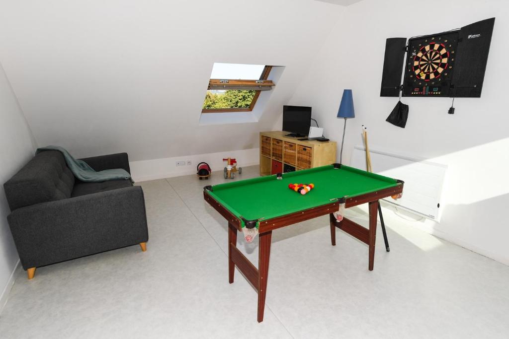 a living room with a pool table and a couch at Maison Mélèry in Saint-Pierre-du-Val