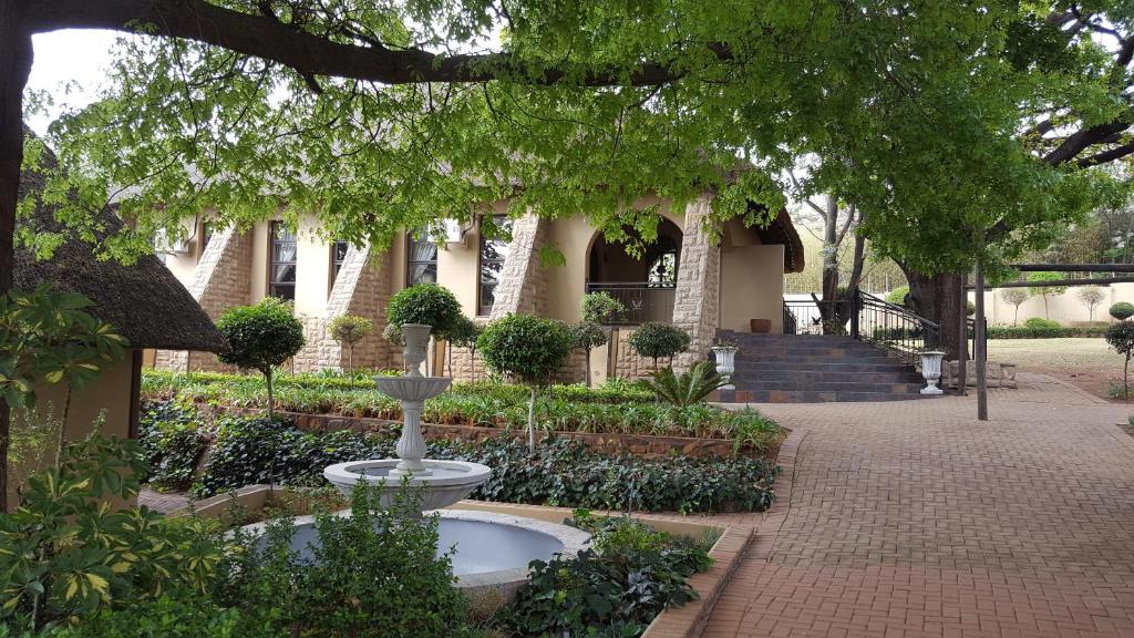a house with a fountain in the middle of a courtyard at Black Eagle Hotel & Spa in Roodepoort