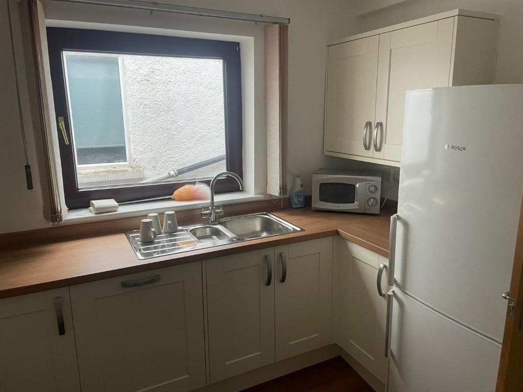 a kitchen with a sink and a white refrigerator at April Disc - Long Stay - Contractors in Bristol