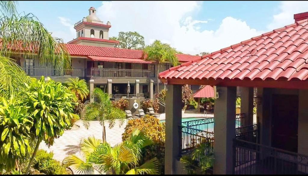 un complexe avec une piscine et un bâtiment avec une tour dans l'établissement Red Roof Inn PLUS & Suites Tampa, à Tampa