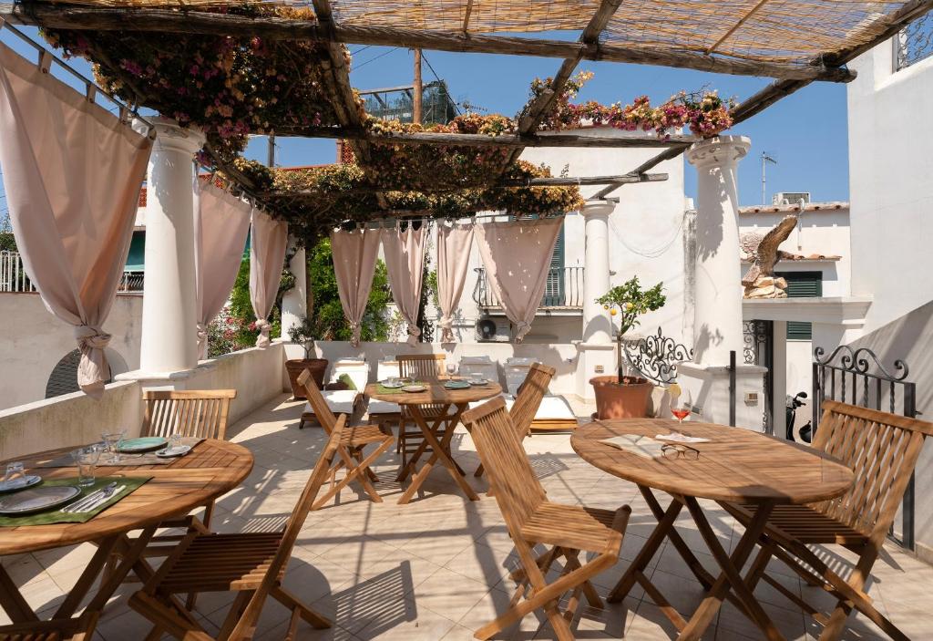 an outdoor patio with wooden tables and chairs at alle Stelle b&b in Anacapri