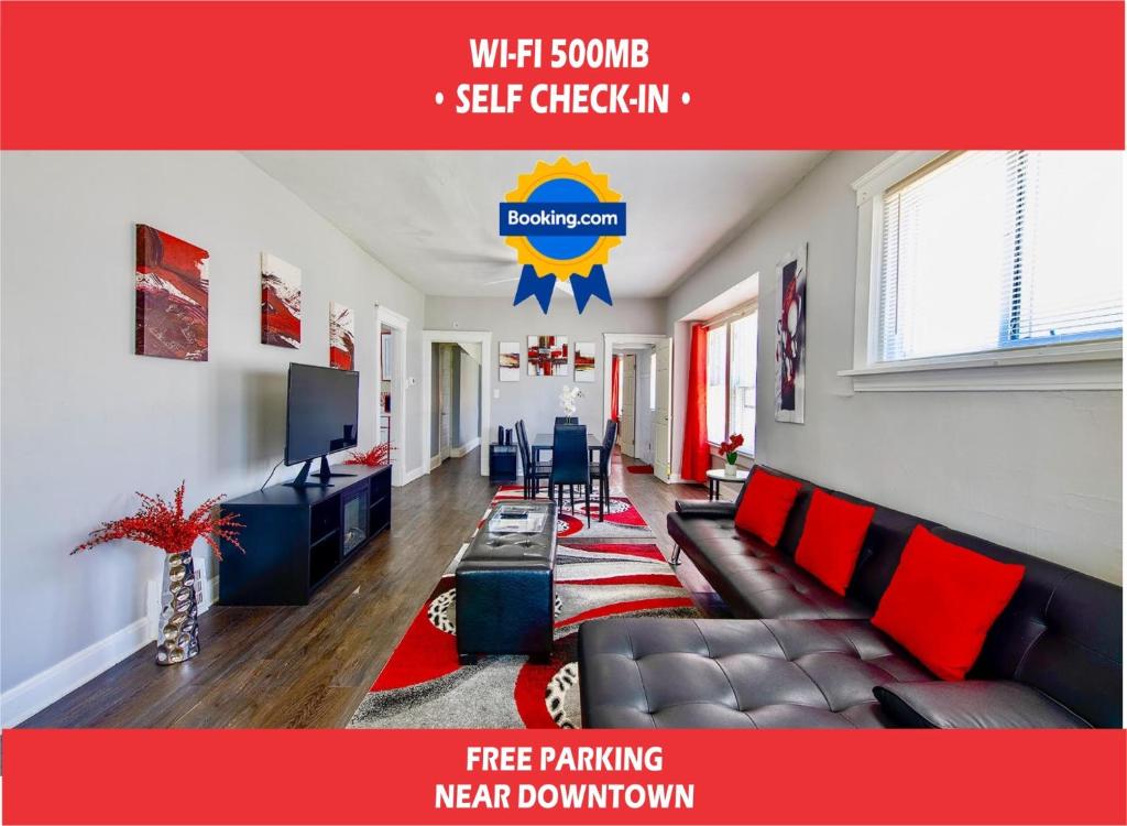 a living room with a couch and a television at The Rubi Lounge - Spacious Brooklyn Centre Modern Escape Near Downtown With Parking, 300MB WiFi & Self Check-In in Cleveland