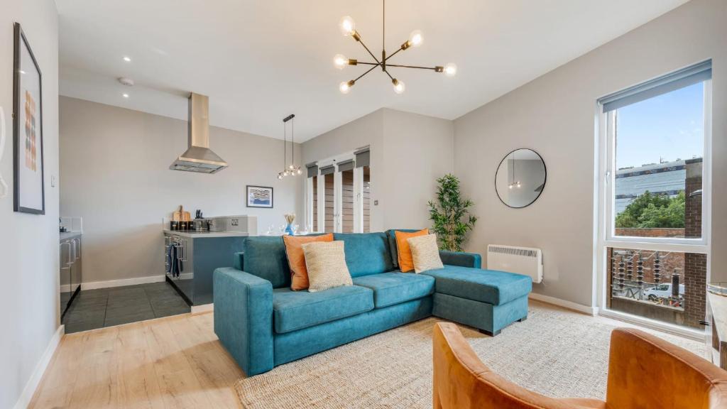 a living room with a blue couch and a kitchen at Host & Stay - Ropewalks Quarters in Liverpool