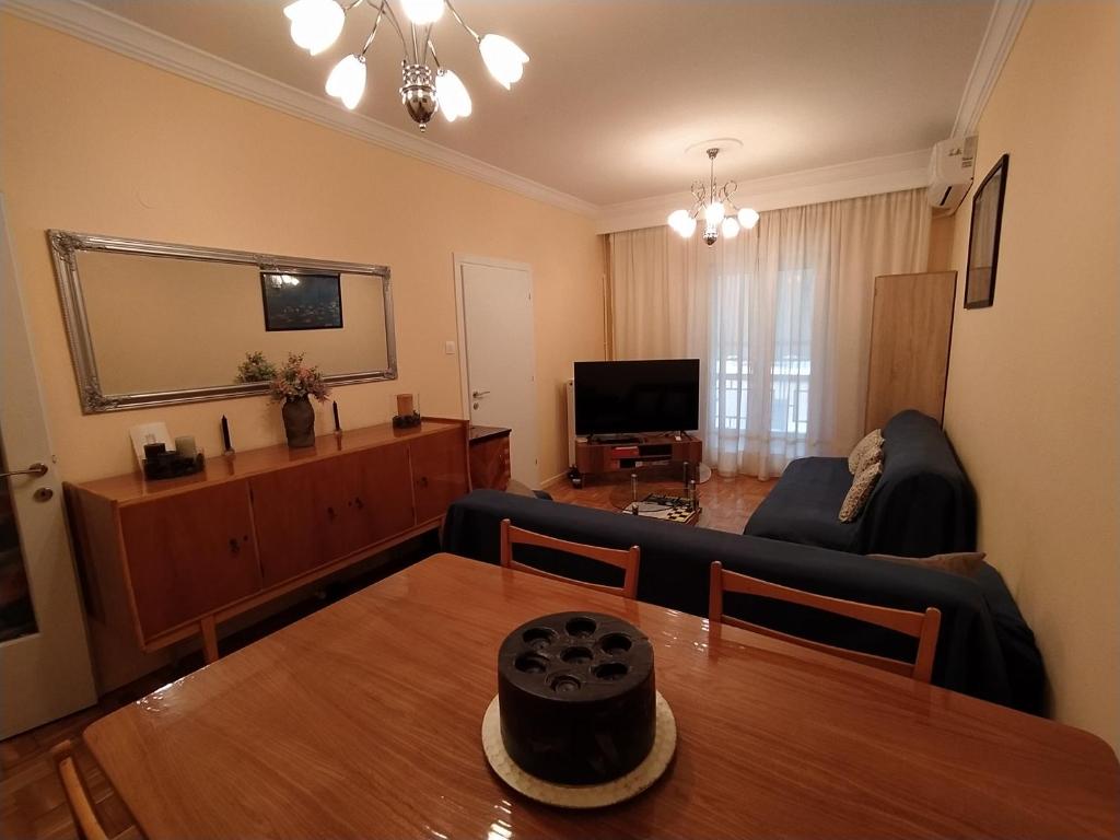 a living room with a table and a couch at Cozy three BDRMS central APT at five Filippou str in Thessaloniki