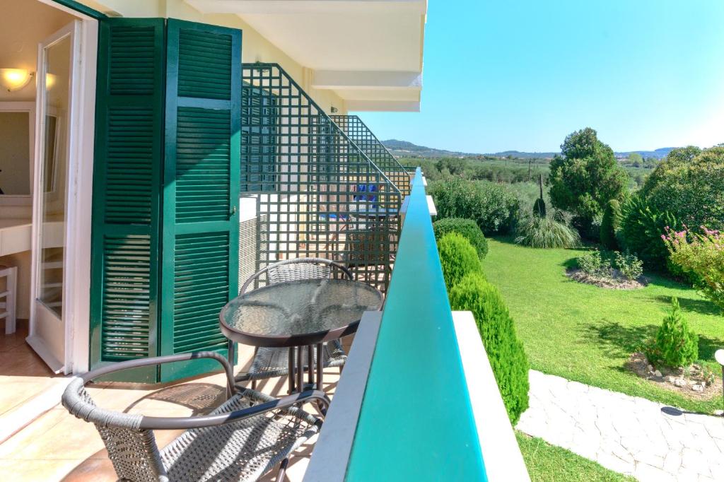 a balcony with two chairs and a view of a yard at Julia Hotel in Fourka