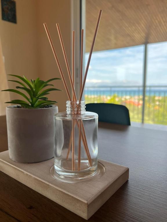 a glass vase with sticks in it on a table at Xenia's Seaview House in Paralía Avlídhos