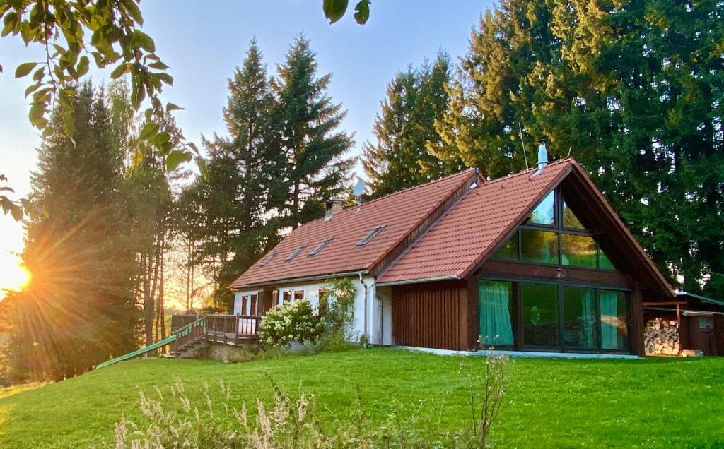 a house on a hill with the sun setting at Bohemian forest paradise 