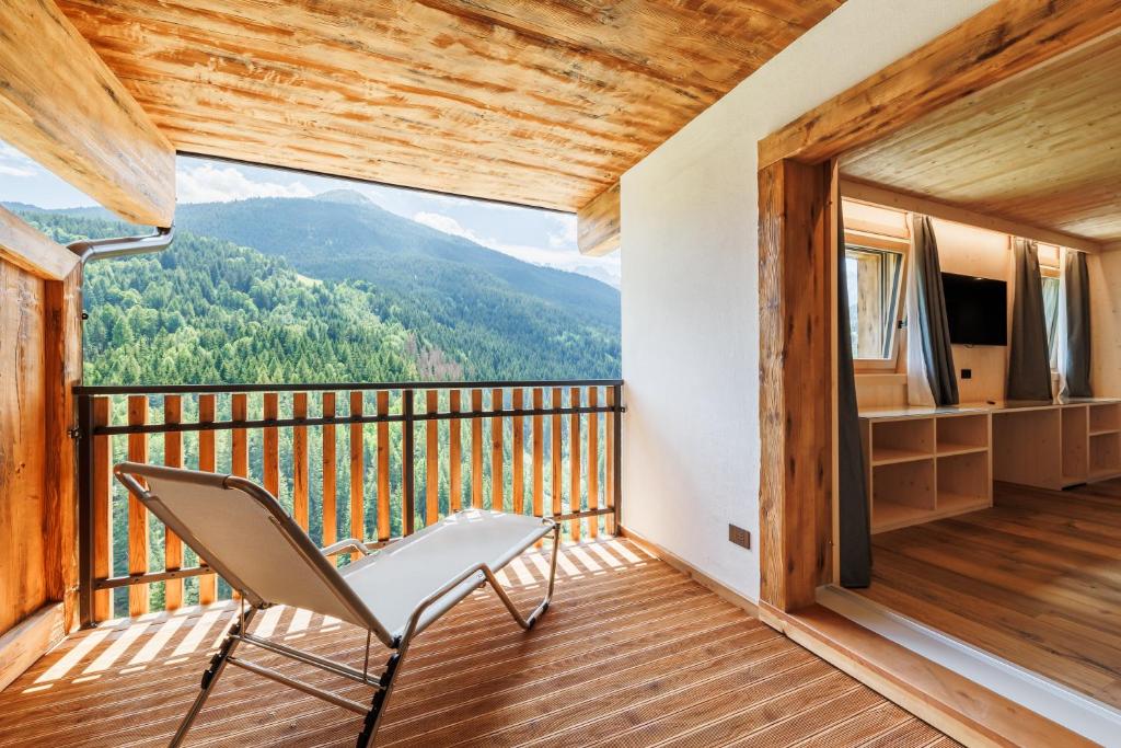 a chair on a balcony with a mountain view at Hotel Miravalle in Valdidentro