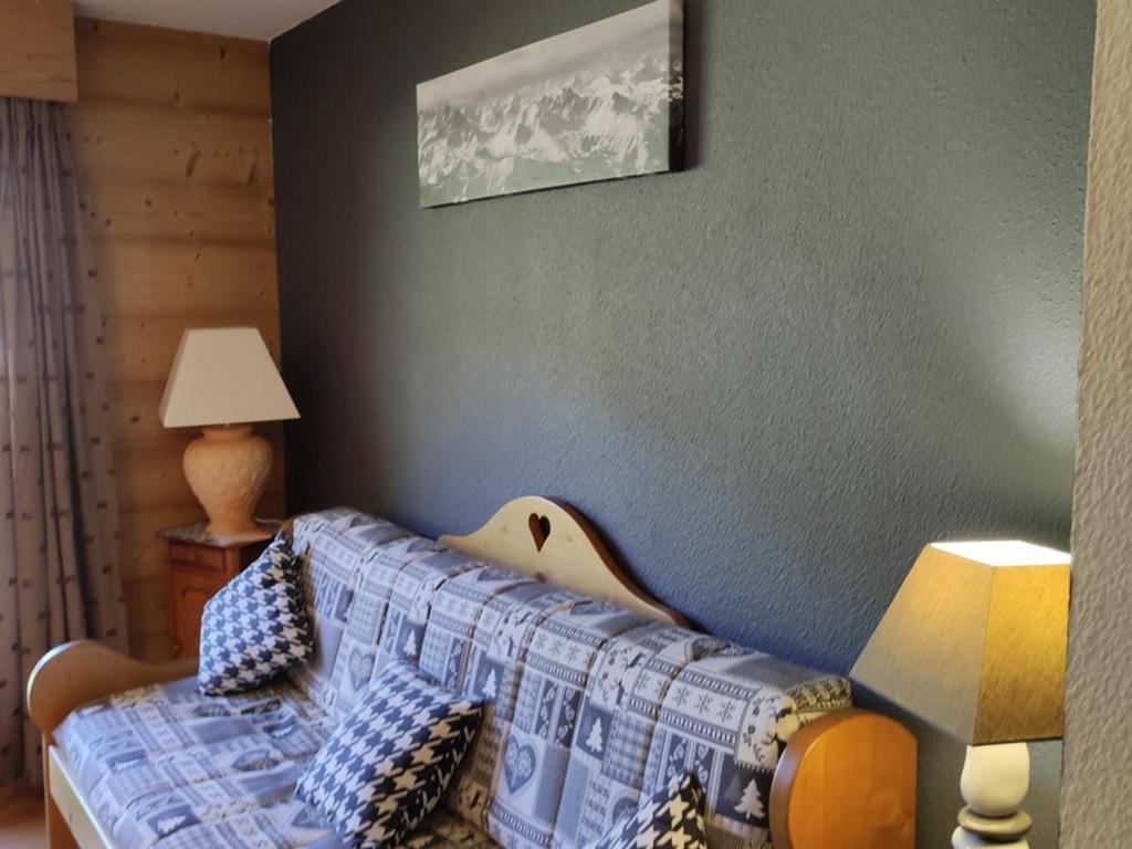 een slaapkamer met een bed met een quilt bij Appartement Saint-Jean-d'Aulps, 2 pièces, 4 personnes - FR-1-573-101 in Saint-Jean-dʼAulps