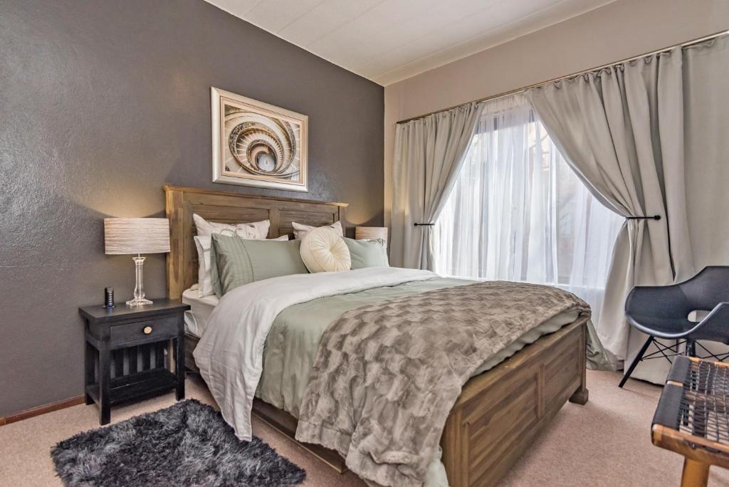 a bedroom with a large bed and a window at CLASSIC A&W in Sandton