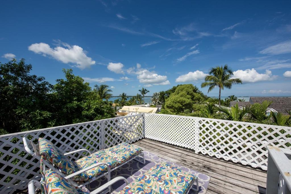 a balcony with chairs and a view of the ocean at Watercolor home in Harbour Island