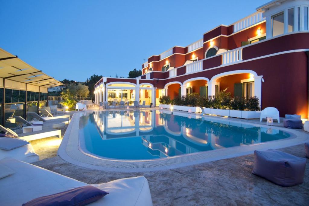 a swimming pool in front of a building at Al Mirador Resort in Selva di Fasano