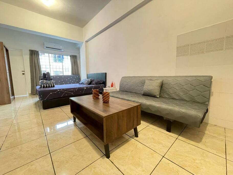 sala de estar con sofá y mesa de centro en KK City A2Z Api Api Cozy Studio Homestay, en Kota Kinabalu