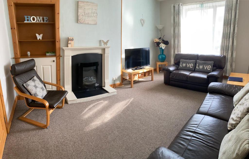 a living room with a couch and a fireplace at Thurso Bay Holidays in Thurso