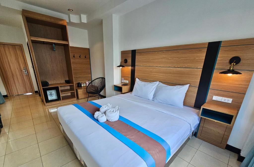 a bedroom with a large bed with two white shoes on it at The Base Inn Pattaya in Pattaya Central