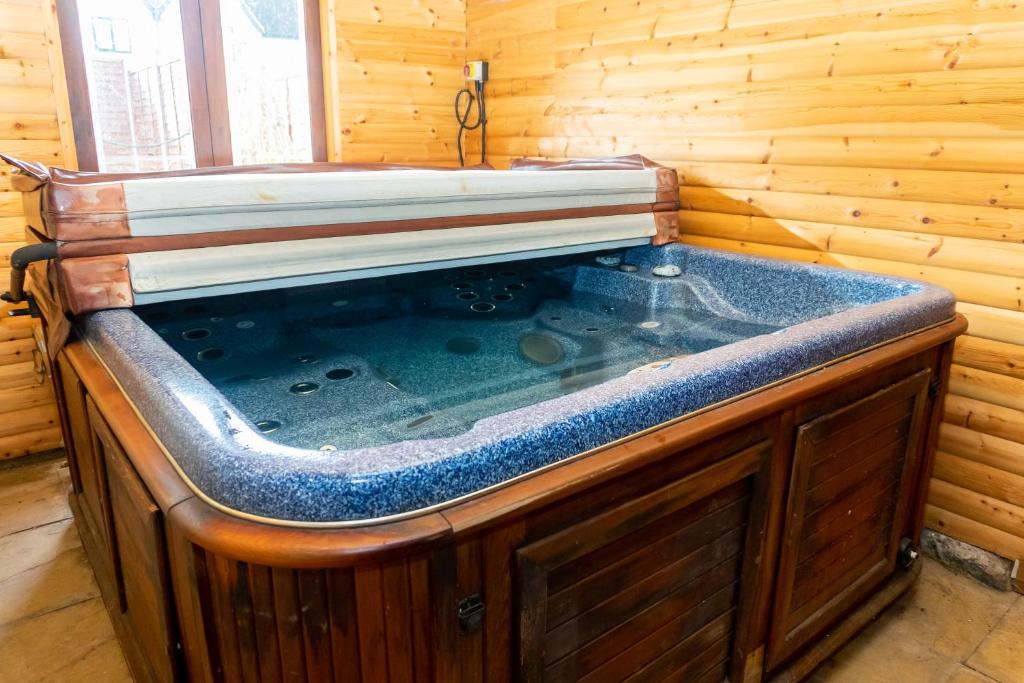 a jacuzzi tub in a wooden cabin at 3 Bed Cottage-Parking-Garden-Free Hot Tub Weekends in Gloucester