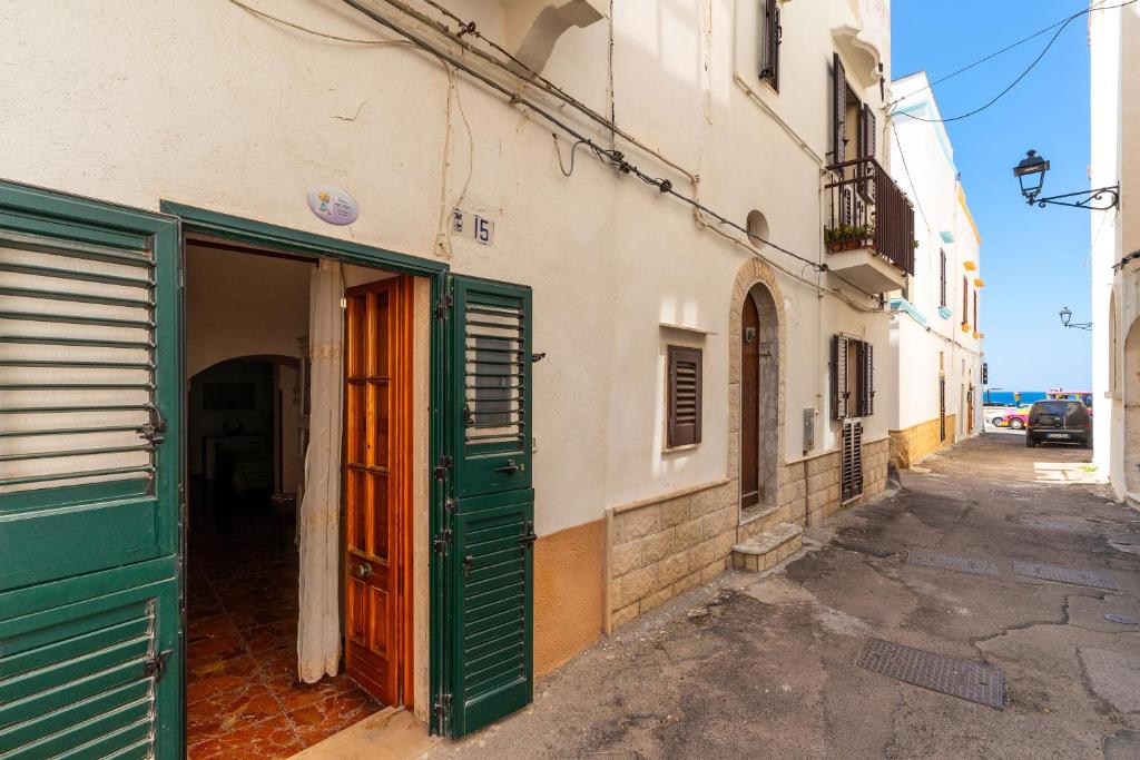 Une allée avec une porte verte dans un bâtiment dans l'établissement Dimora degli Angeli by BarbarHouse, à Gallipoli