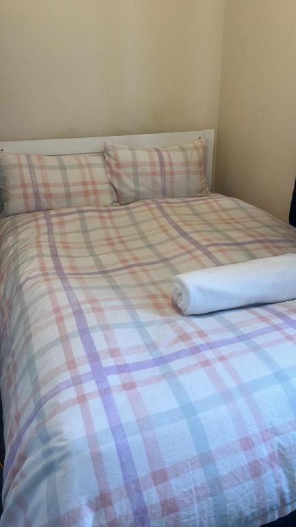 1 cama con manta a cuadros y almohadas en Kleber house en Bristol