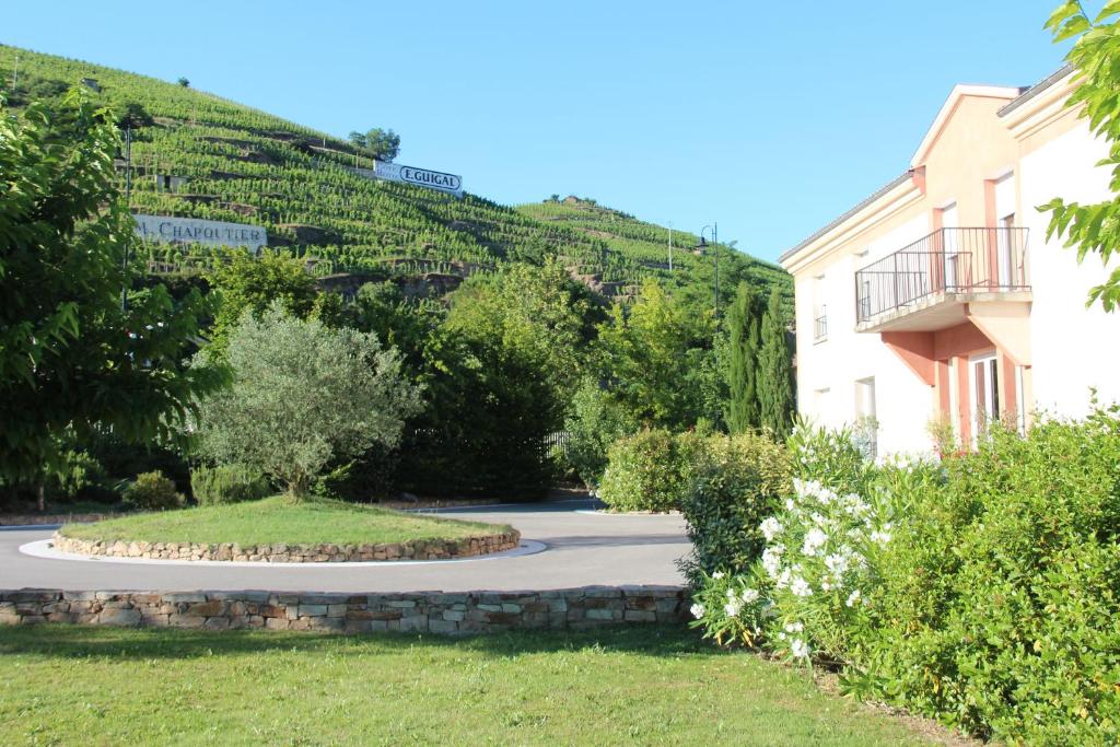 un jardín frente a un edificio en Hôtel Le Domaine des Vignes Ampuis Lyon Sud Vienne, en Ampuis