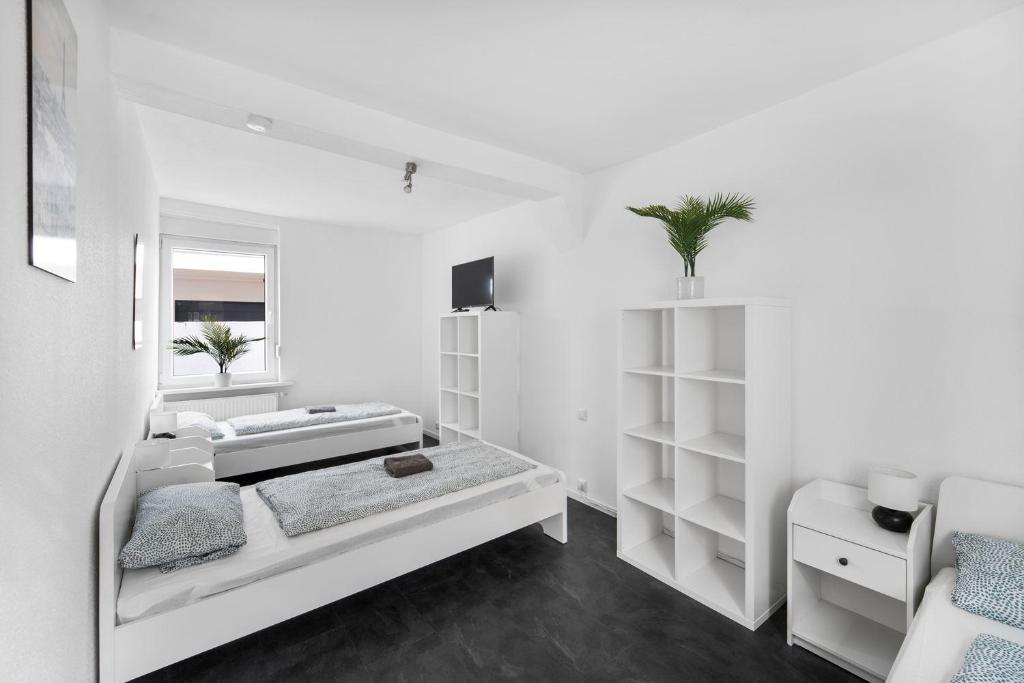 Habitación blanca con 2 camas y TV. en Schicke Monteurwohnung in Celle, en Celle