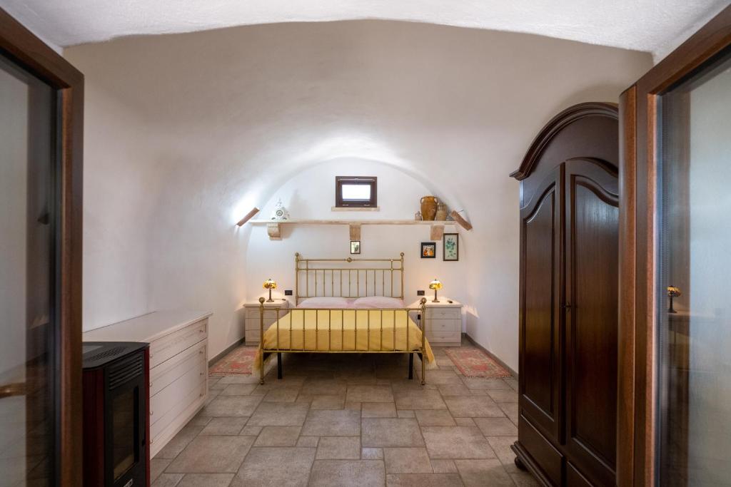 um quarto com uma cama com um cobertor amarelo em La Pajara em Tricase
