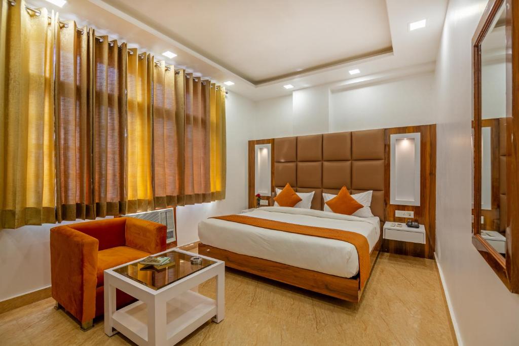 a hotel room with a bed and a chair at Hotel Rahul Palace By Golden Tree at Karol Bagh in New Delhi