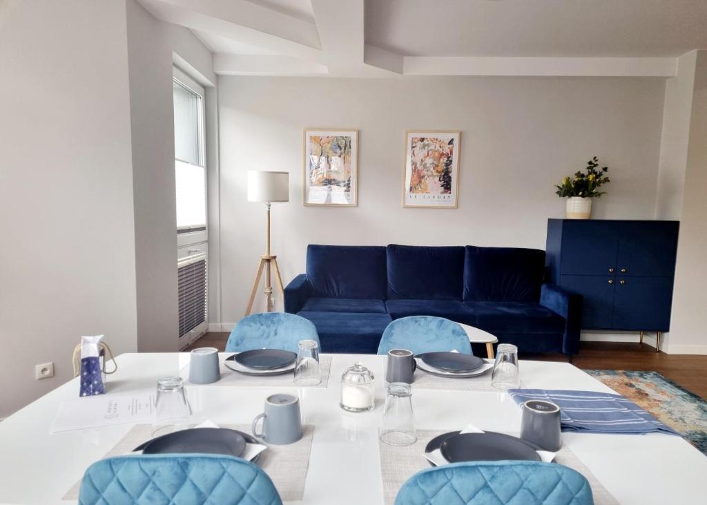 Aparthotel Bukowa في تيخي: غرفة معيشة مع طاولة وأريكة زرقاء