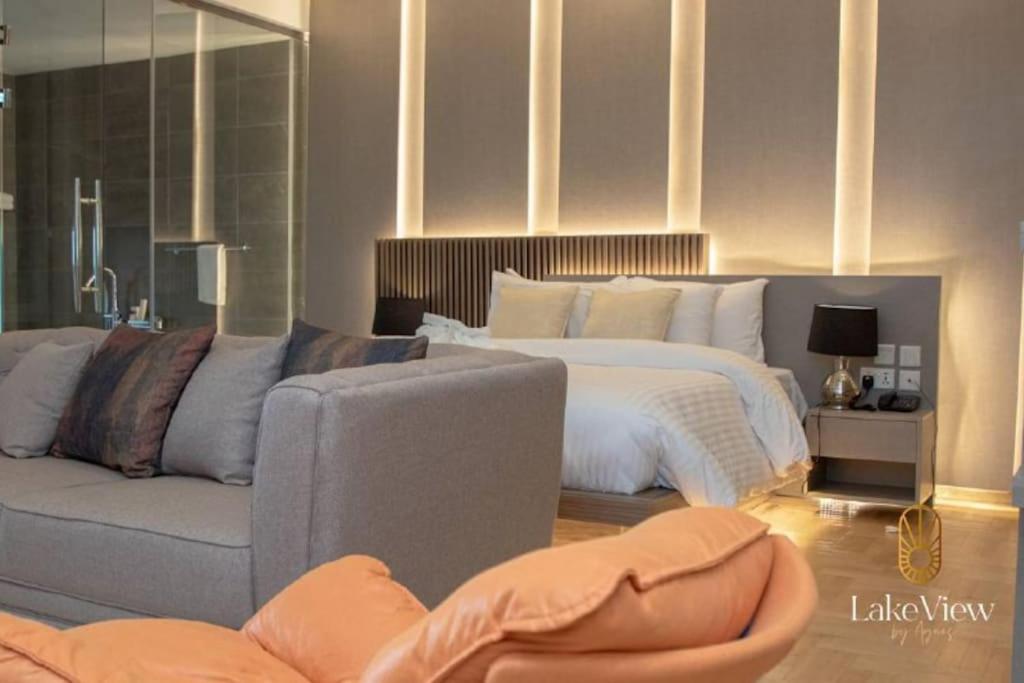 um quarto com uma cama grande e um sofá em Executive Suite Apartment in Cape Coast - Lakeview by Agnes em Cape Coast