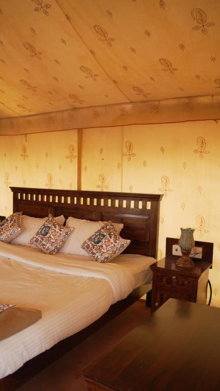 a bedroom with a bed with pillows on it at Bikaner Desert Camp and Resort in Bikaner