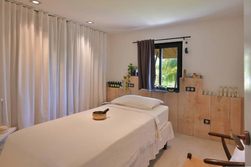 ein Schlafzimmer mit einem großen weißen Bett und einem Fenster in der Unterkunft Case Canne a sucre in Saint Barthelemy