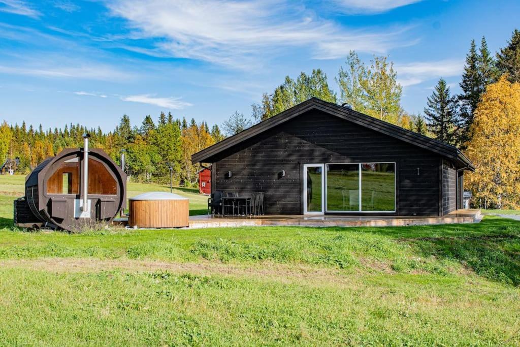 mały czarny dom z okrągłym domem w obiekcie Villa Black w mieście Slussfors