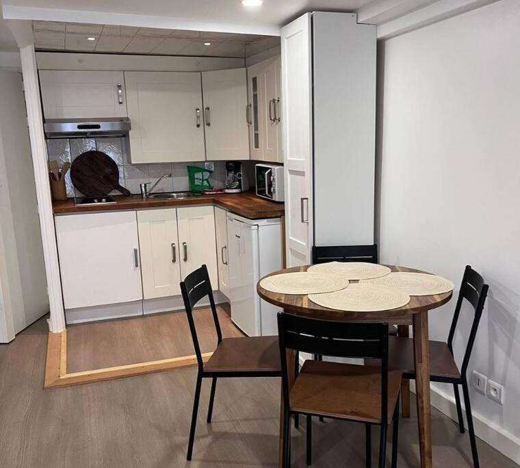 a kitchen with a table and chairs in a room at Le Bayard YourHostHelper in Grenoble