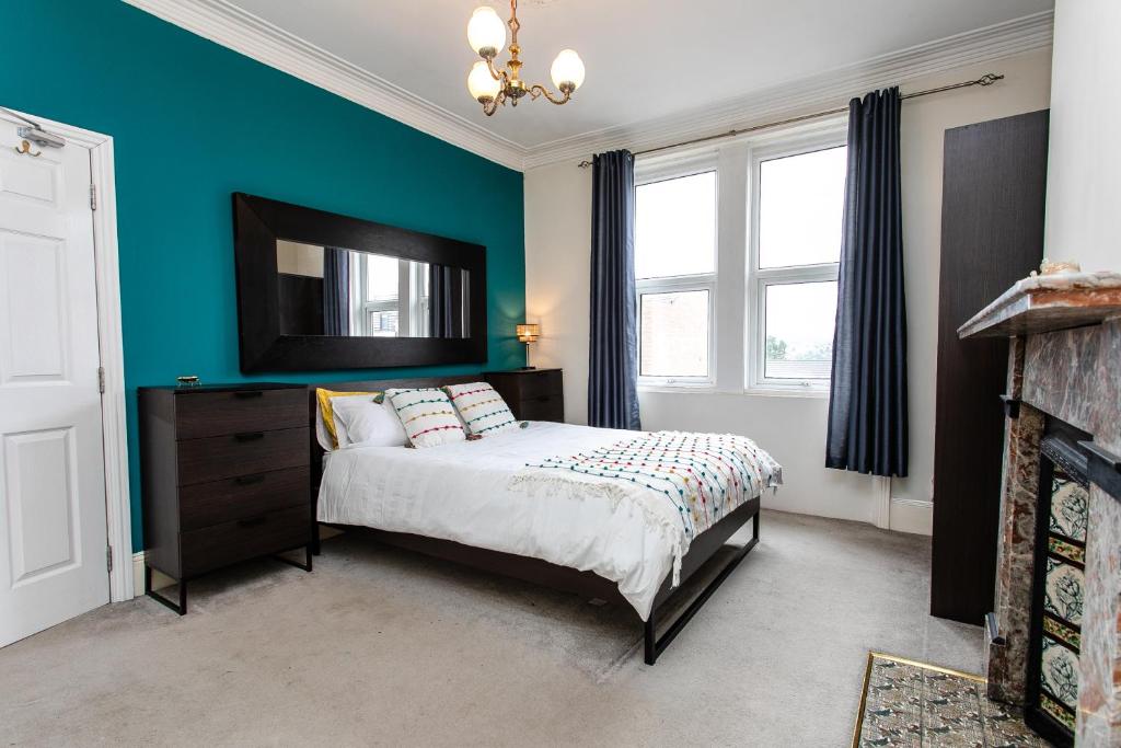 1 dormitorio con cama y pared azul en Saltwell Oasis: 5-Bed Delight en Low Team