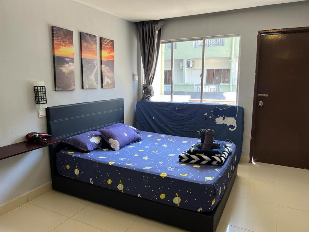 a bedroom with a bed with a blue comforter with stars at KK City A2Z Api Api Studio Homestay in Kota Kinabalu