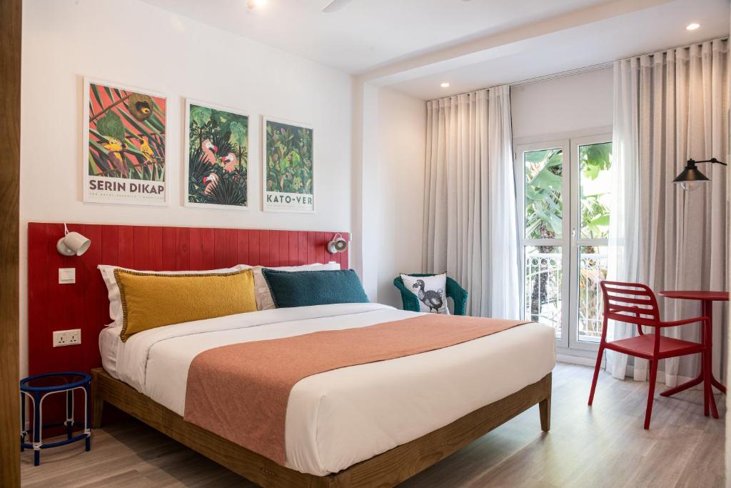 sypialnia z dużym łóżkiem i czerwoną ścianą w obiekcie Dodo Square w mieście Grand Baie