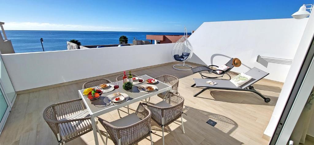 a balcony with a table with food and a laptop at Ferienwohnung OCEAN SOUNDS 2 in Gran Tarajal