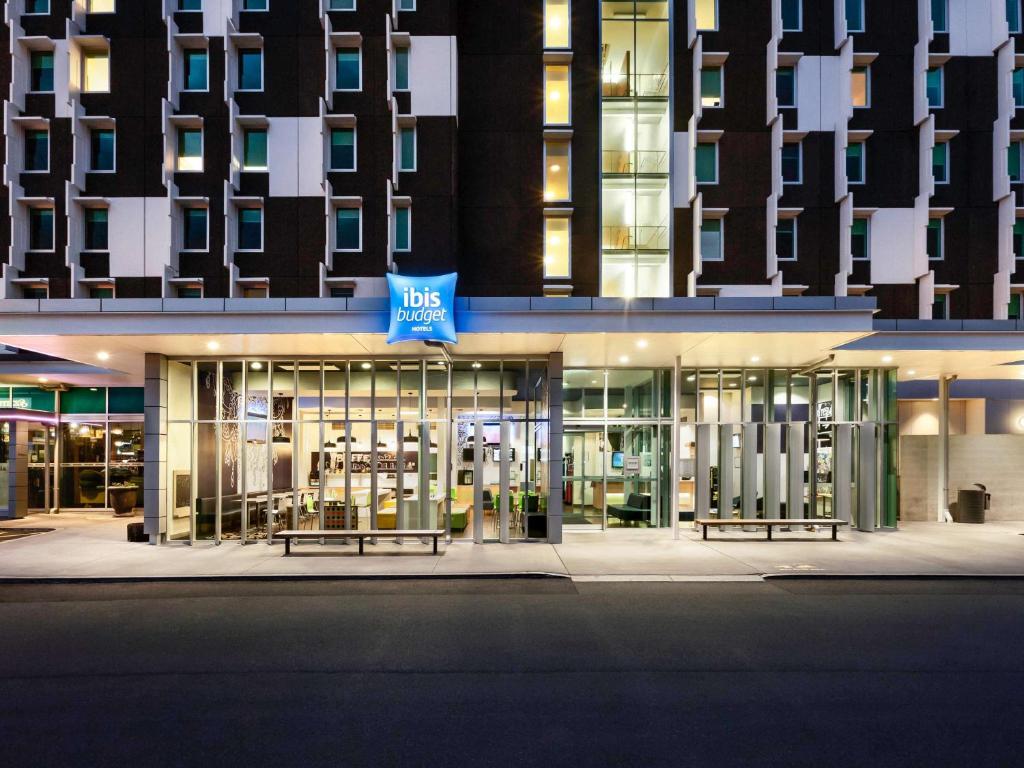 a building with a blue sign on the front of it at ibis Budget Auckland Airport in Auckland