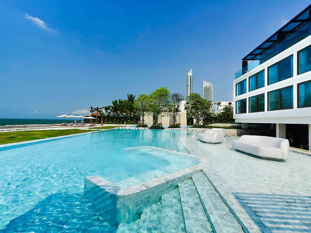 a large swimming pool next to a building at Veranda Resort Pattaya - MGallery by Sofitel in Jomtien Beach