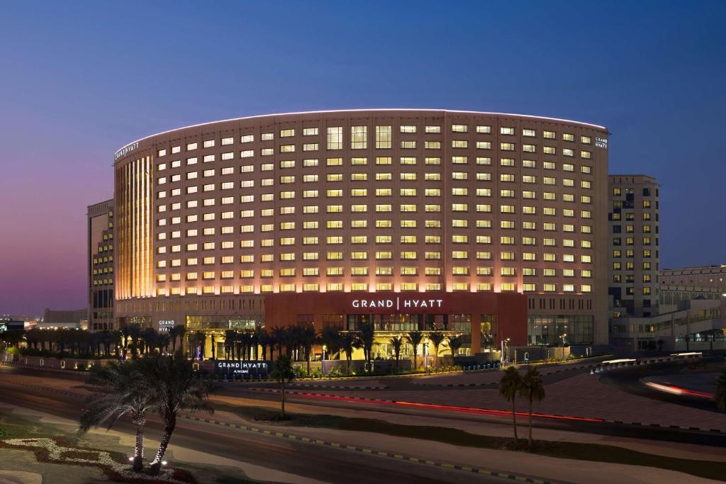 Grand Hyatt Al Khobar Hotel and Residences في الخبر: مبنى كبير مع إضاءة في مدينة