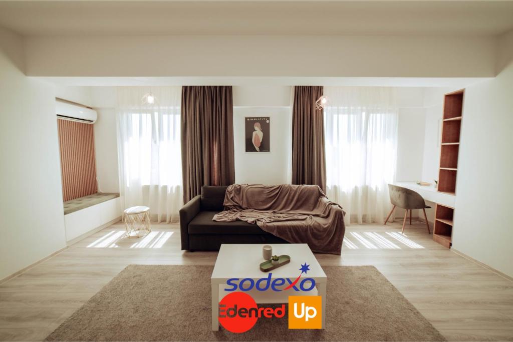 ein Wohnzimmer mit einem Sofa und einem Tisch in der Unterkunft Cozy Apartments - One Residence Iasi in Iaşi