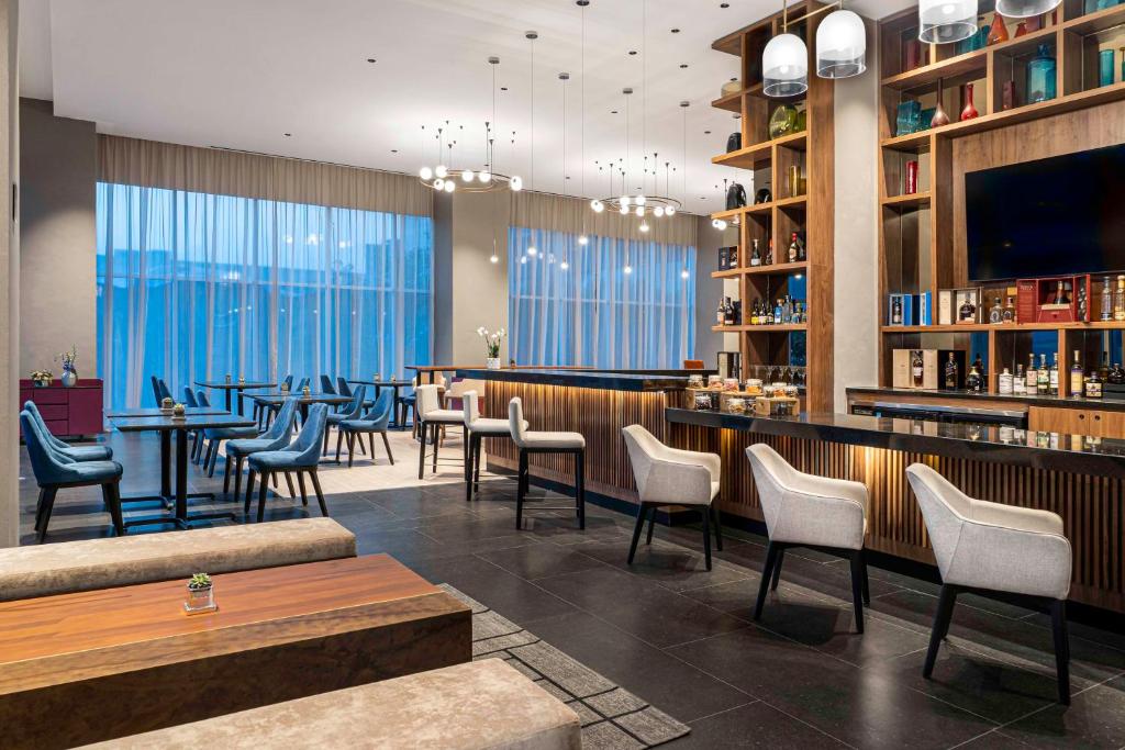 a restaurant with a bar with chairs and tables at Hyatt Regency Mexico City Insurgentes in Mexico City