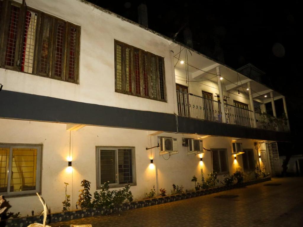 a white building with a balcony at night at Libra Cottage in Port Blair