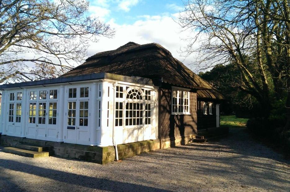 um pequeno edifício com telhado de palha em Thornton Manor - Holiday Cottages and Apartments em Heswall