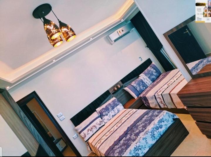 a bedroom with two twin beds and a lamp at شقه اكثر روعه فيو بحر مباشر in Alexandria