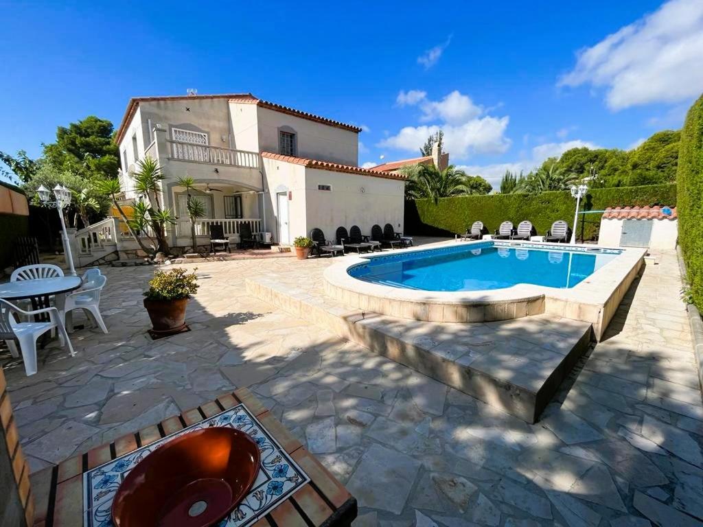 a backyard with a swimming pool and a house at Villa Preciosa in Les tres Cales