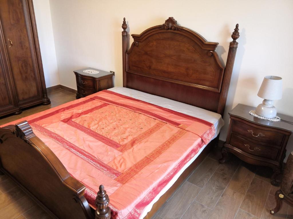 1 dormitorio con cama de madera y manta roja en للسيدات Master bedroom for ladies only Sheik Zayed, en Sheikh Zayed